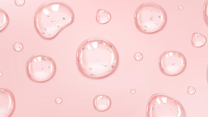 Droplets of a clear mist on a peach colored surface